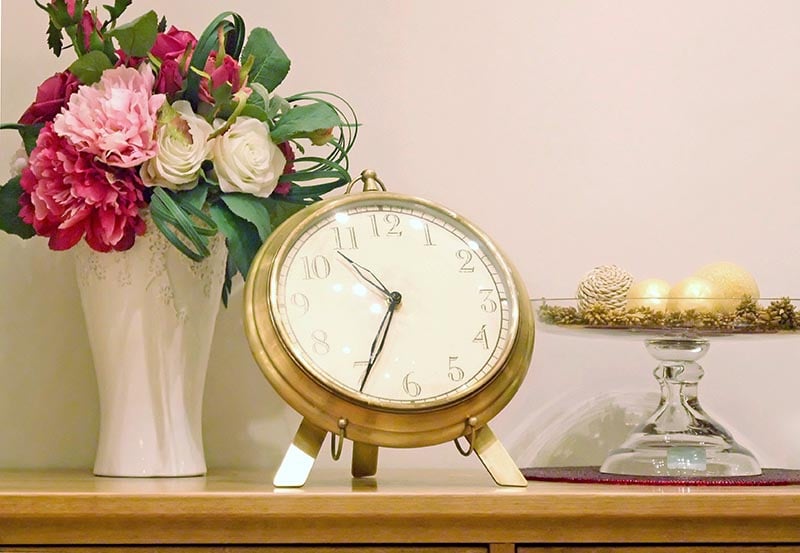 A decorative tabletop arrangement set against a plain beige wall.